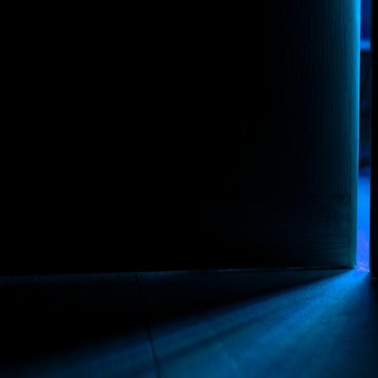 En dør på klem i et mørkt rum.