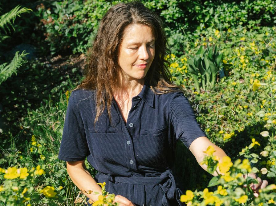 Line Hassall Thomsen, der plukker urter udendørs.